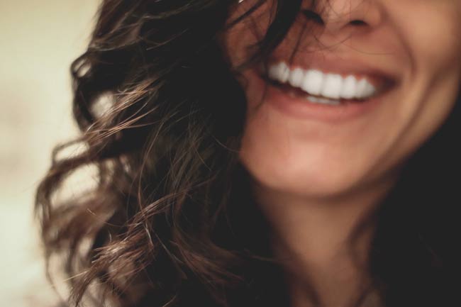start meditating and start smiling more. a woman with dark hair and a big smile.